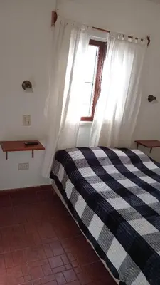 a bedroom with a bed and a window at CASONA Malva del Rio in Villa Carlos Paz