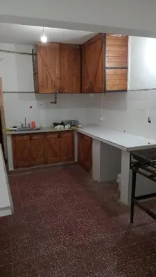 a kitchen with wooden cabinets and a white counter top at CASONA Malva del Rio in Villa Carlos Paz