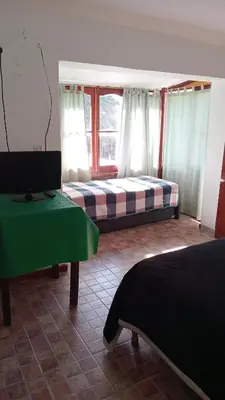a bedroom with two beds and a window at CASONA Malva del Rio in Villa Carlos Paz