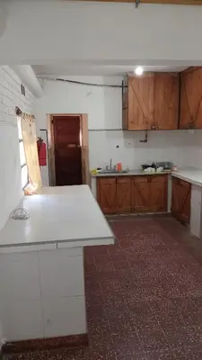 a kitchen with wooden cabinets and a white counter top at CASONA Malva del Rio in Villa Carlos Paz