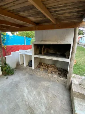 a outdoor oven with a table and fire logs at CASONA Malva del Rio in Villa Carlos Paz