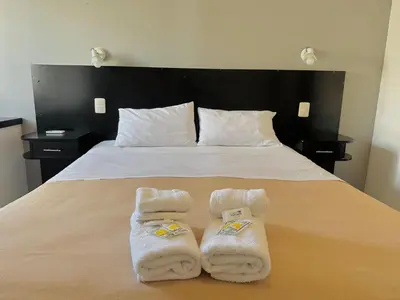 a bedroom with a bed with towels on it at Hotel Toulon in Villa Carlos Paz
