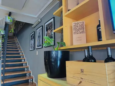 a room with a staircase with wine bottles on a shelf at Hotel Toulon in Villa Carlos Paz