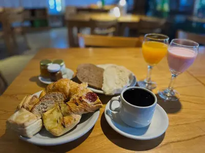 a table with a plate of bread and a cup of coffee at Hotel Toulon in Villa Carlos Paz