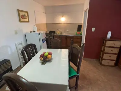 a kitchen with a table with a bowl of fruit on it at departamentos pama in Santa Rosa de Calamuchita