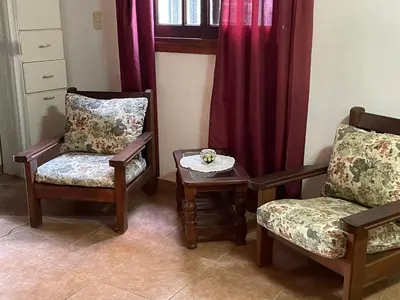 a living room with two chairs and a table at departamentos pama in Santa Rosa de Calamuchita