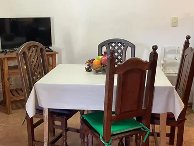 a dining room table with a bowl of fruit on it at departamentos pama in Santa Rosa de Calamuchita