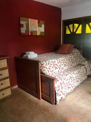 a bedroom with a bed with a wooden dresser at departamentos pama in Santa Rosa de Calamuchita
