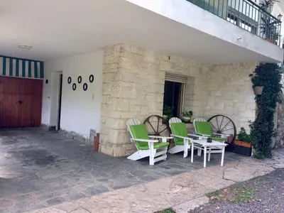 a group of green chairs and tables on a patio at departamentos pama in Santa Rosa de Calamuchita