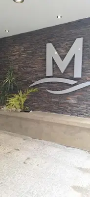 a large m sign on the side of a brick wall at Miralejos 17 in Villa Carlos Paz
