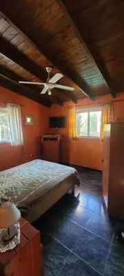 a bedroom with a bed and a ceiling fan at Cabaña Hakuna matata in Santa Rosa de Calamuchita