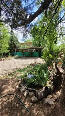 a garden with a hose in front of a building at Cabaña Hakuna matata in Santa Rosa de Calamuchita