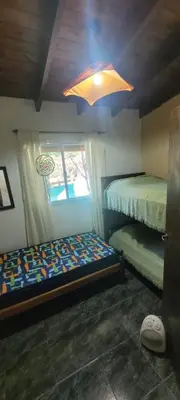 a bedroom with a bed and a window and a light at Cabaña Hakuna matata in Santa Rosa de Calamuchita