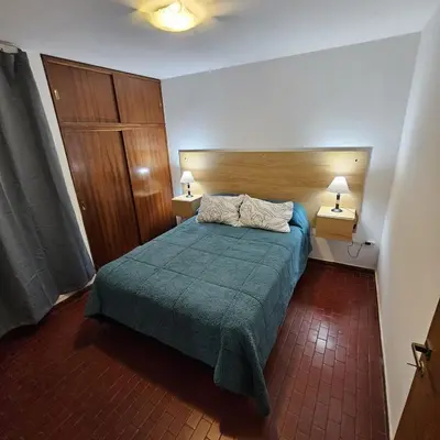 a bedroom with a bed with a green blanket and two lamps at Apartment in the City of Cordoba for 4 people and parking in Cordoba