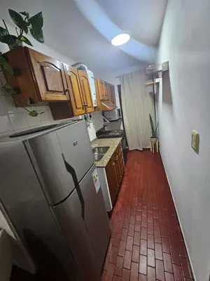 a kitchen with a refrigerator and a red tile floor at Apartment in the City of Cordoba for 4 people and parking in Cordoba