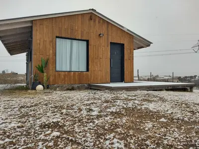 a small wooden house with a window in a field at algo con sierras in Villa Yacanto
