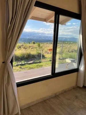 a window in a room with a view of a field at algo con sierras in Villa Yacanto