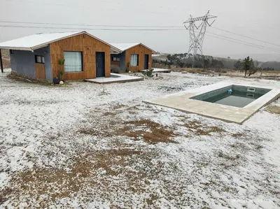 a house with a swimming pool in a field with snow at algo con sierras in Villa Yacanto