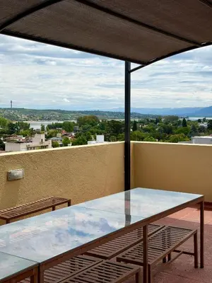 a glass table on a balcony with a view at Departamento en el corazón de Villa Carlos Paz in Villa Carlos Paz
