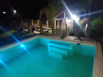 a swimming pool at night with lights in it at Cabañas aguaribay in Villa Parque Siquiman
