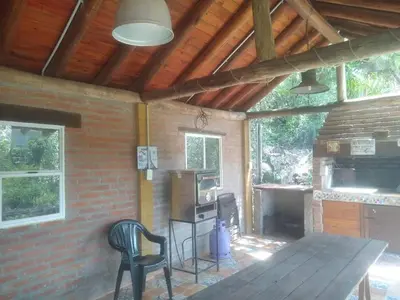 a patio with a table and chairs in a house at Cabañas aguaribay in Villa Parque Siquiman