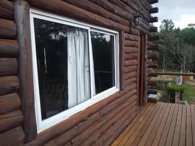 a window on the outside of a log cabin at Cabañas aguaribay in Villa Parque Siquiman