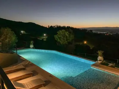 a large swimming pool with blue water at night at Postal de América in Villa Ciudad de America
