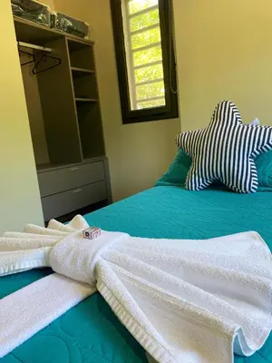 a bedroom with towels on a bed with a mirror at Postal de América in Villa Ciudad de America