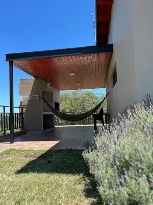 a porch with a hammock on the side of a house at Postal de América in Villa Ciudad de America