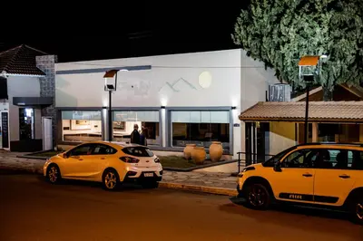 two cars parked in front of a building at night at Clima Sol in Merlo