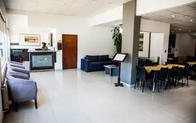a lobby with a couch and chairs and a tv at Clima Sol in Merlo