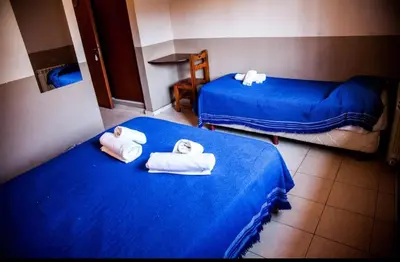 two beds with towels on them in a room at Clima Sol in Merlo