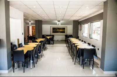 a row of tables and chairs in a dining room at Clima Sol in Merlo