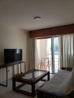 a living room with a tv and a coffee table at Departamento en calle 9 de Julio in Cordoba