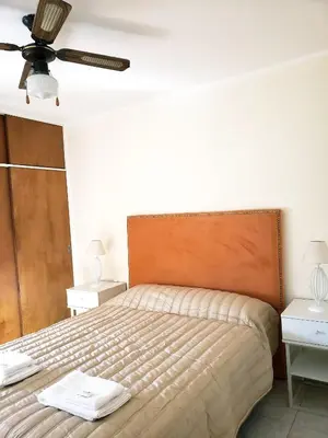 a bedroom with a bed and a ceiling fan at Departamento en calle 9 de Julio in Cordoba