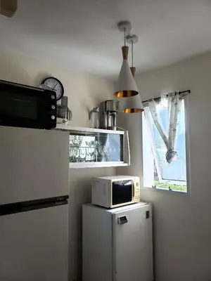 a microwave on top of a refrigerator in a kitchen at Departamento en calle 9 de Julio in Cordoba
