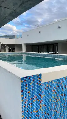 a swimming pool in a building with a blue tile at Departamento Villa 5 in Villa Carlos Paz