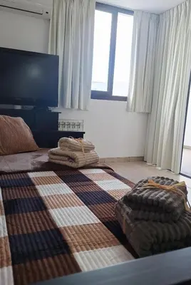 a bedroom with a large bed with a blanket on it at Departamento Villa 5 in Villa Carlos Paz