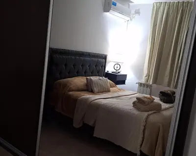 a bedroom with a large bed with a mirror at Departamento Villa 5 in Villa Carlos Paz