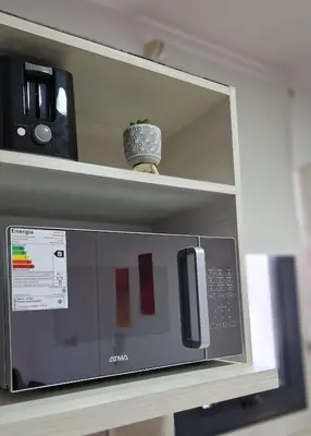 a microwave on a shelf with a pot on top of it at Departamento Villa 5 in Villa Carlos Paz