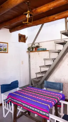 a table and two chairs in a room with stairs at Casita Meraki Duplex para 3 personas in Villa Carlos Paz