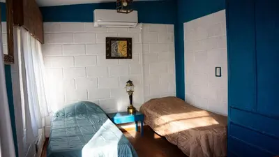 a blue room with a bed and a table at Casita Meraki Duplex para 3 personas in Villa Carlos Paz