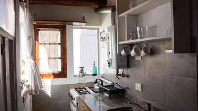 a kitchen with a sink and a stove and a window at Casita Meraki Duplex para 3 personas in Villa Carlos Paz