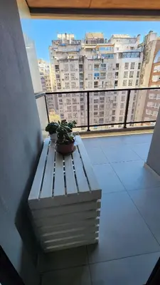 a potted plant sitting on a bench in front of a window at Obispo Salguero 648 - Pleno Nueva Cordoba BY Apartcba in Cordoba