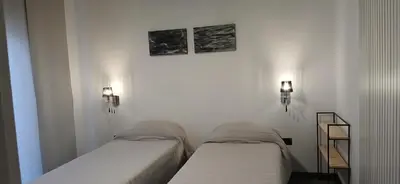 two beds in a room with two lights on the wall at alecayluna in Berrotarán