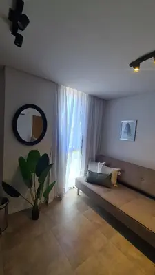 a living room with a couch and a large window at ALLEGRA Lake Towers - Nuevo y moderno! Exc ubicación -Lo vas a amar in Villa Carlos Paz