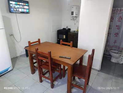 a dining room table with chairs and a television at Soles in Cordoba