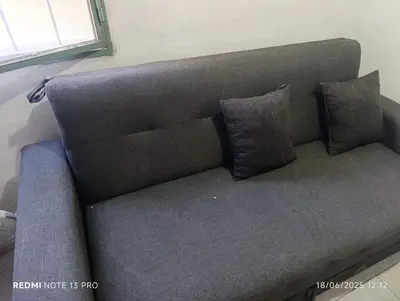 a couch with two pillows on it in a room at Soles in Cordoba