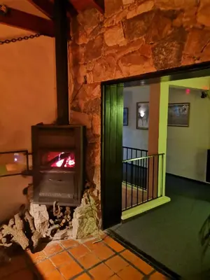 a wood burning stove in a room with a balcony at Casa Alta Hotel Boutique & Spa - Solo Adultos in Villa Carlos Paz