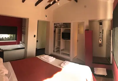 a bedroom with two beds and a bathroom with a tub at Casa Alta Hotel Boutique & Spa - Solo Adultos in Villa Carlos Paz